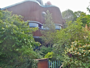 La maison d'acier, toute en courbe, avec un toit terrasse comme un paquebot, à voir sur la photo générale de la rue.
